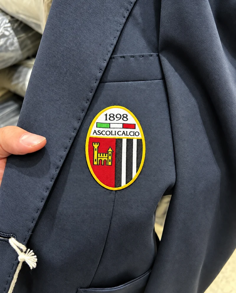 Giacca blu con stemma Ascoli Calcio 1898 applicato sul taschino.