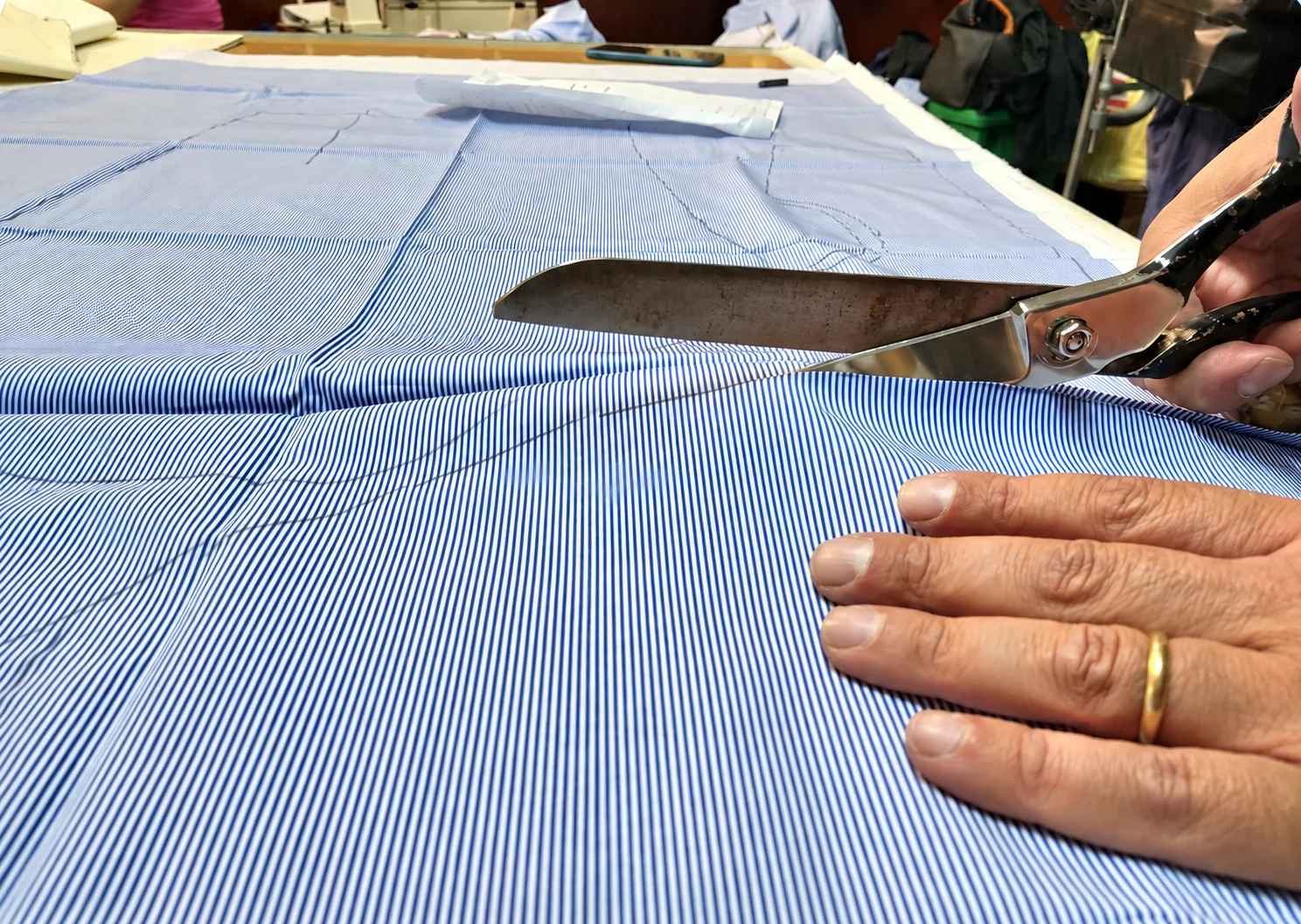 Il taglio di una camicia a righe azzurre, nel laboratorio di Antonio Gigliotti.